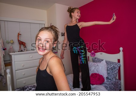 Two young girls playing and taking a selfie in their room
