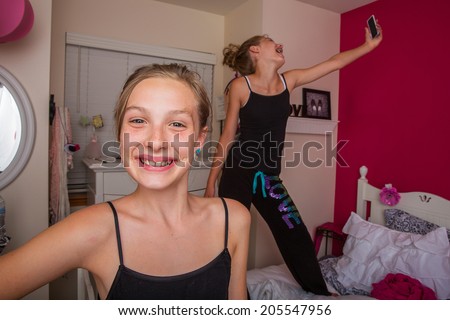 Two happy kids playing in their room and taking selfies with their cellphone