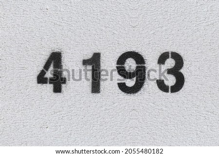 Black Number 4193 on the white wall. Spray paint. Number four thousand one hundred ninety three.