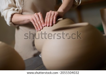 Picture of potters hands molding a shape of a pot