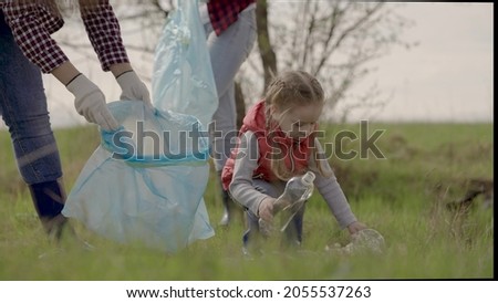 Little kid with family collect garbage in trash park, happy family, environmental cleanup volunteer team, pollution problem, plastic pollution and environmental problem concept Royalty-Free Stock Photo #2055537263