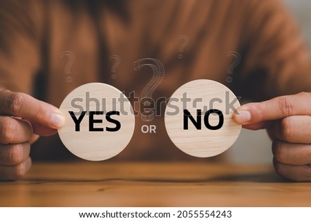 Think With Yes Or No Choice, Business Choices For Difficult Situations, Yes or no and question mark, man holding two wooden with yes or no word on it, making decision. Royalty-Free Stock Photo #2055554243