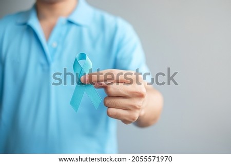 November Prostate Cancer Awareness month, Man in blue shirt with hand holding Blue Ribbon for supporting people living and illness. Healthcare, International men, Father and World cancer day concept Royalty-Free Stock Photo #2055571970