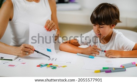 Child coloring shapes in a preschool assessment test.