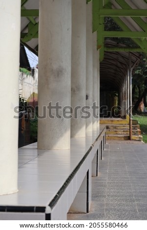 a bus stop with big pillars but quiet with no prospective passengers waiting
