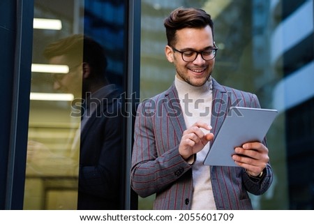 Portrait of successful man using digital tablet in urban background. Business people concept