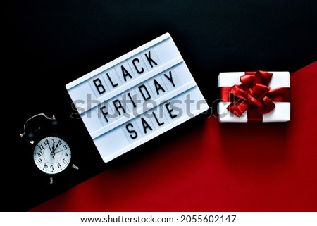 Creative composition. BLACK FRIDAY SALE text on lightbox, alarm clock and gift box on a red and black background. Copy space. Square Template, Black friday sale, mockup fall thanksgiving advertising