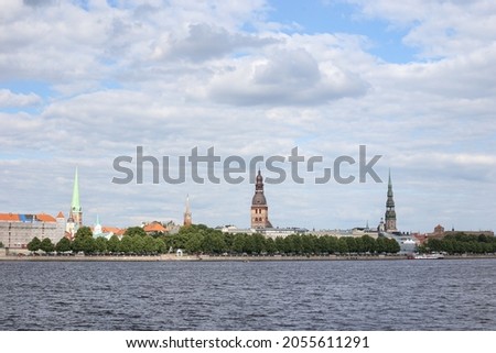 Cityscape view of old Riga architecture buildings and churches near river Daugava. Photo taken on a warm summer overcast day.