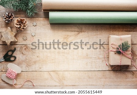 Wrapping Christmas presents in kraft paper minimial Christmas creative background with copy space, New Year and Christmas gifts wrapping supplies on wooden background