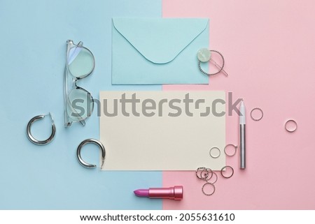 Composition with blank card, envelope and female accessories on color background