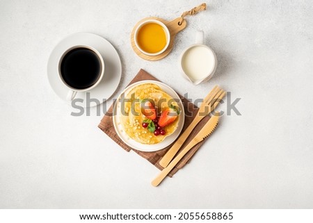 Morning served breakfast set: pancakes, porridge, cottage cheese, granola, muesli, orange juice, tea, coffee, fruits and berries.
