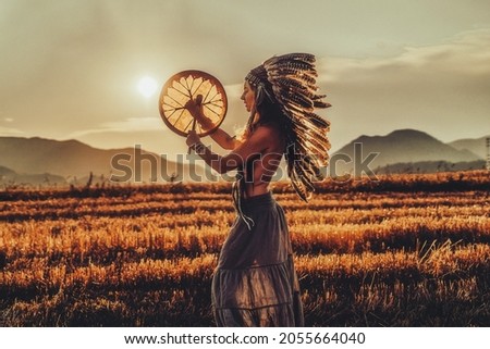 beautiful shamanic girl playing on shaman frame drum in the natu