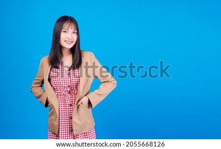 Lifestyle, winner concept. Positive smile happy business young woman holding hand in pocket suit with success job or lucky while standing over isolated blue background.