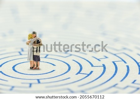 Family issues and problems concept : Parents, father, mother, daughter hug each other in a maze, depicting a family has problems and hardly find the ways or solutions to cope, escape or deal with them Royalty-Free Stock Photo #2055670112