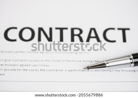 Pens and contract documents are placed on the desk.