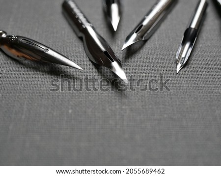 Drawing pens, fountain pens with different nibs on a textured surface