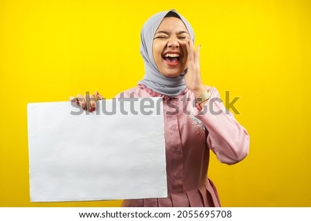 Pretty young muslim woman cheerful holding blank empty banner, placard, white board, blank sign board, white advertisement board, presenting something in copy space, promotion