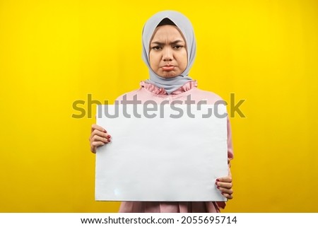 Pretty young muslim woman sad holding blank empty banner, placard, white board, blank sign board, white advertisement board, presenting something in copy space, promotion