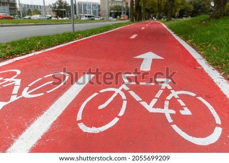 traffic, road marking and city concept - red bike lane with signs of bicycles and two way arrows on street in tallinn