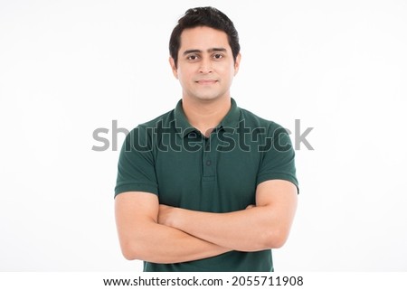 Smiling handsome Asian man in casual black t-shirt with arm crossed looking at camera studio shot isolated on white background