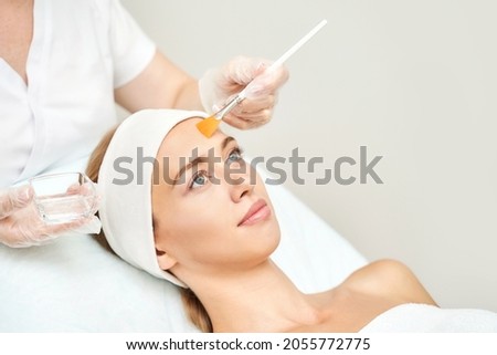Cosmetology beauty procedure. Young woman skin care. Beautiful female person. Rejuvenation treatment. Facial chemical peel therapy. Clinical healthcare. Doctor hand. Dermatology cleanser. Royalty-Free Stock Photo #2055772775