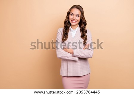 Portrait of charming satisfied girl toothy smile look empty space crossed arms isolated on beige color background