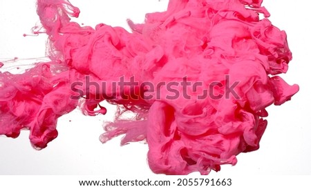 Awesome abstract background. Drops of pink ink in water. Pink watercolor ink in water on a white background. Colored acrylic paints in water. Pink cloud of ink on a white background.