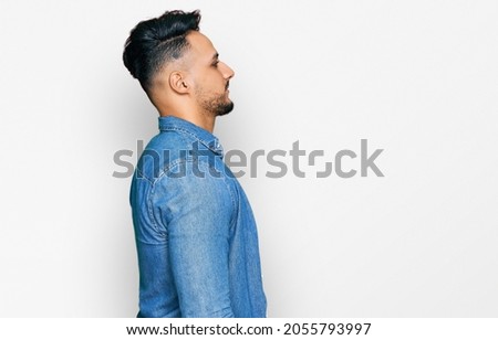 Young arab man wearing casual clothes looking to side, relax profile pose with natural face with confident smile. 
