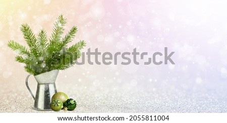 Christmas glitter background. A decorative jug or vase with fir twigs and Christmas balls for decoration on a dull background.