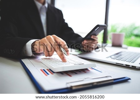 Close-up shot of woman pressing a calculator to review and summarize the cost of mortgage home loans for refinancing plans, lifestyle concept. Royalty-Free Stock Photo #2055816200
