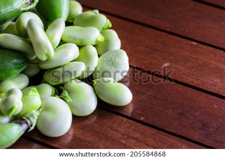 closeup of broad bean on wooden table - stock photo