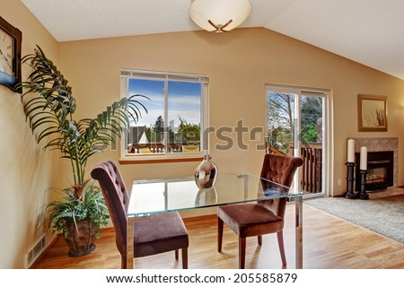Dining area with glass top table and velvet chairs. Decorated with palm tree.