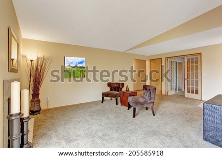 Empty living room in soft ivory with fireplace. Room decorated with candles and dry branches.