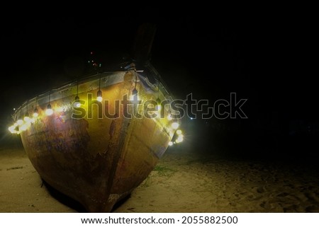 Fishing boats at night are decorated with different colored lights.