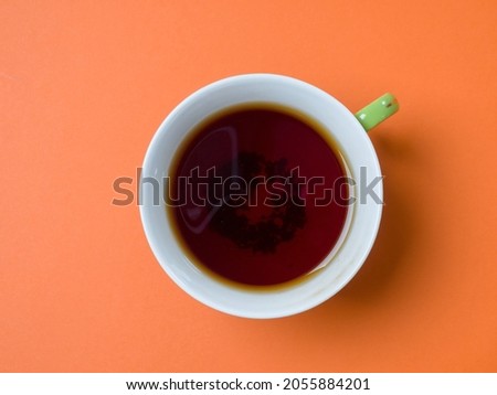 Mug of tea on an orange background. View from above. Studio photography