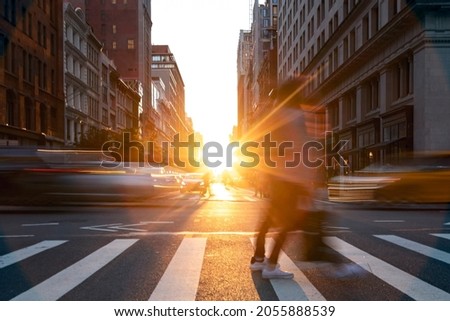 People and cars crossing the busy intersection on 5th Avenue with sunset light shining on 5th Avenue in Manhattan, New York City NYC Royalty-Free Stock Photo #2055888539