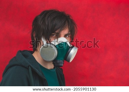 Man in respirator mask on red background. male portrait in gas mask. pollution concept