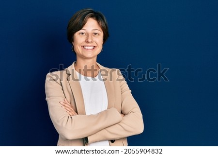 Young business woman smiling happy and confident with crossed arms standing over isolated background