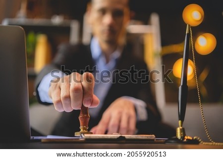 Close-up of a person's hand stamping with approved stamp on approval certificate document public paper at desk, notary or business people work from home, isolated for coronavirus COVID-19 protection Royalty-Free Stock Photo #2055920513