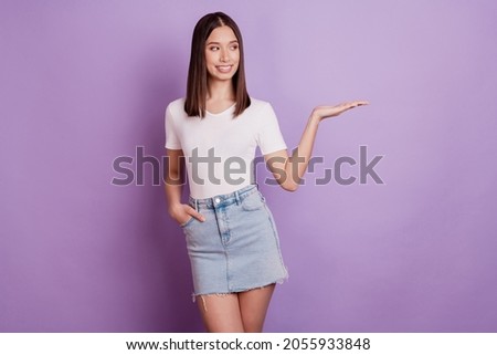 Photo of young attractive girl happy positive smile look hand product promo offer sale isolated over violet color background