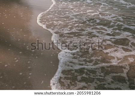 The texture is soft sand on the surf line.