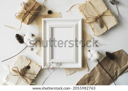 A horizontal photo frame surrounded by vintage letters lies on a white table. 