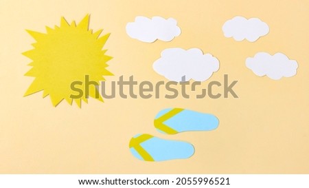 Paper sun and clouds, beach flip-flops run nearby. Summer cartoon. Top view.