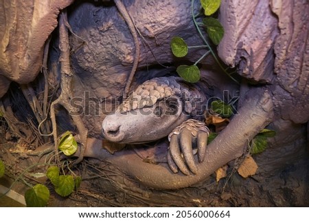Manis pentadactyla 
statue in a hollow tree. manis javanica.  Royalty-Free Stock Photo #2056000664