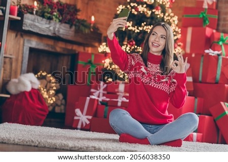 Portrait of attractive trendy cheerful girl taking selfie showing ok-sign blogging at loft industrial style interior decorated home indoors