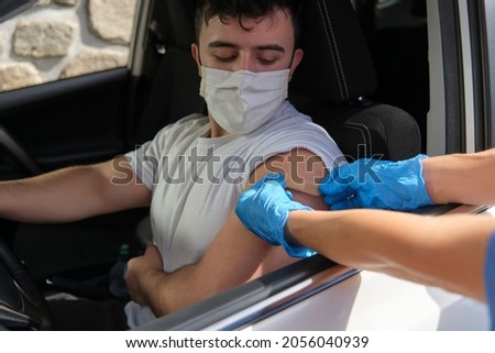 A nurse applies a plaster to the place of vaccination on the arm.