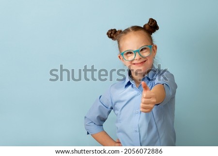 Happy girl with Down syndrome having fun and laughing in the studio Royalty-Free Stock Photo #2056072886