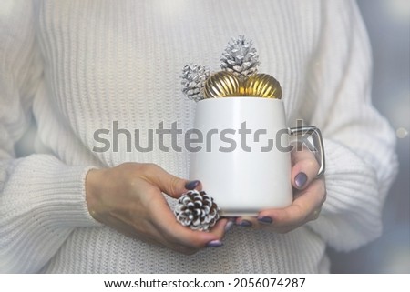 white christmas cup on woman hands with pine cones-winter mug close up for new year time concept