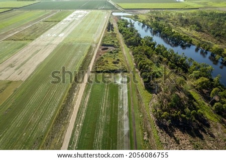 Aerial landscape by drone of a tree lined lagoon wildlife reserve surrounded by sugarcane fields Royalty-Free Stock Photo #2056086755