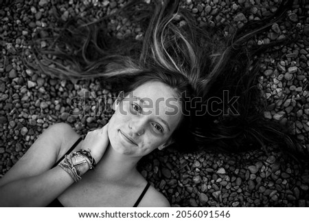 A teen girl is lying, a picture from above close-up. Black and white photo.